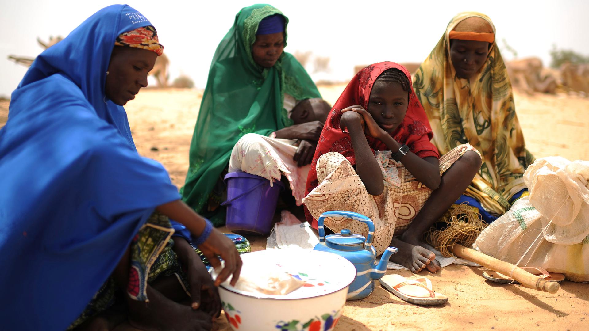 Frauen sitzen zusammen in der von Hunger bedrohten Sahelzone. Frauen sitzen zusammen in der von Hunger bedrohten Sahelzone.