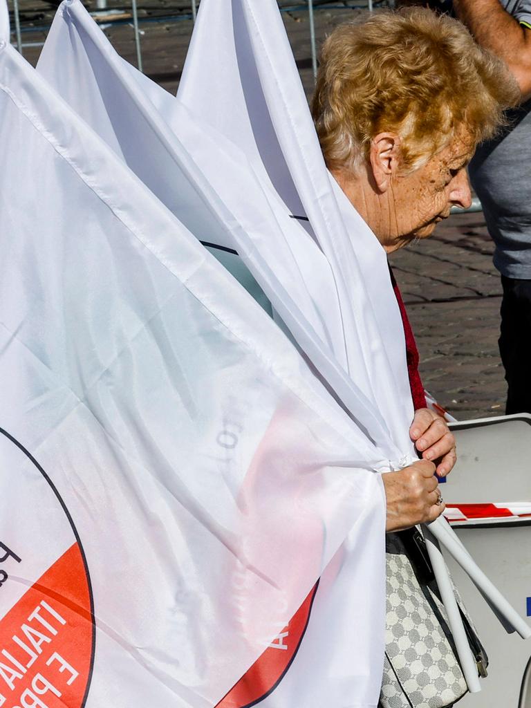 Die Partito Democratico beendet ihren Wahlkampf. Eine Frau sammelt gebeugt die Fahnen ein nach einer der letzten Wahlkampfveranstaltungen in Rom. Die Partito Democratico beendet ihren Wahlkampf. Eine Frau sammelt gebeugt die Fahnen ein nach einer der letzten Wahlkampfveranstaltungen in Rom.