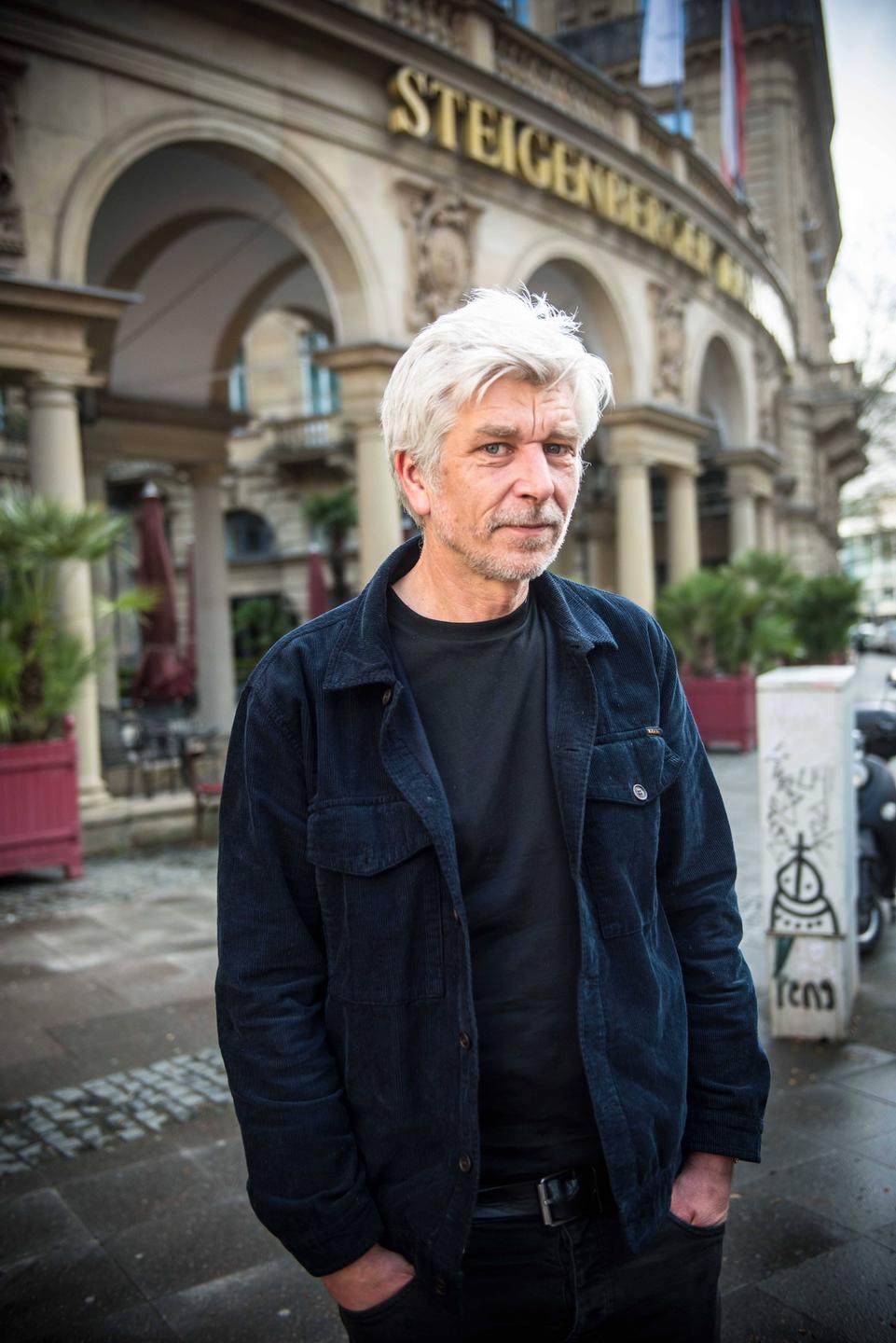 Karl Ove Knausgård steht lässig vor einem Hotel und blickt in die Kamera. Karl Ove Knausgård steht lässig vor einem Hotel und blickt in die Kamera.