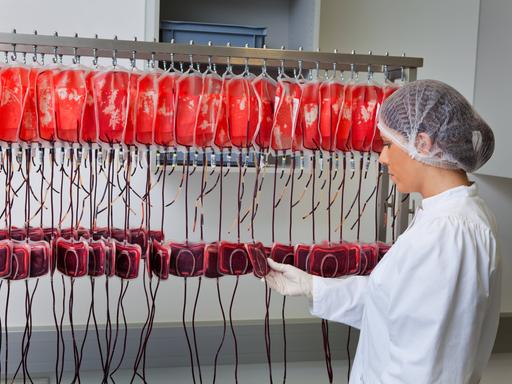 Eine Ärztin untersucht im Labor die gespendeten Blutkonserven. 