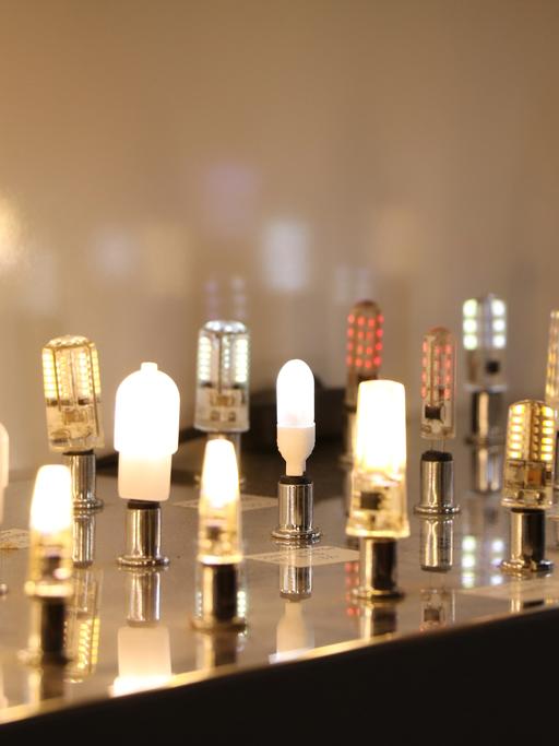 Ganz viele LEDßEnergiesparlampe stehen aufgereiht, wie auf einer Bühne.