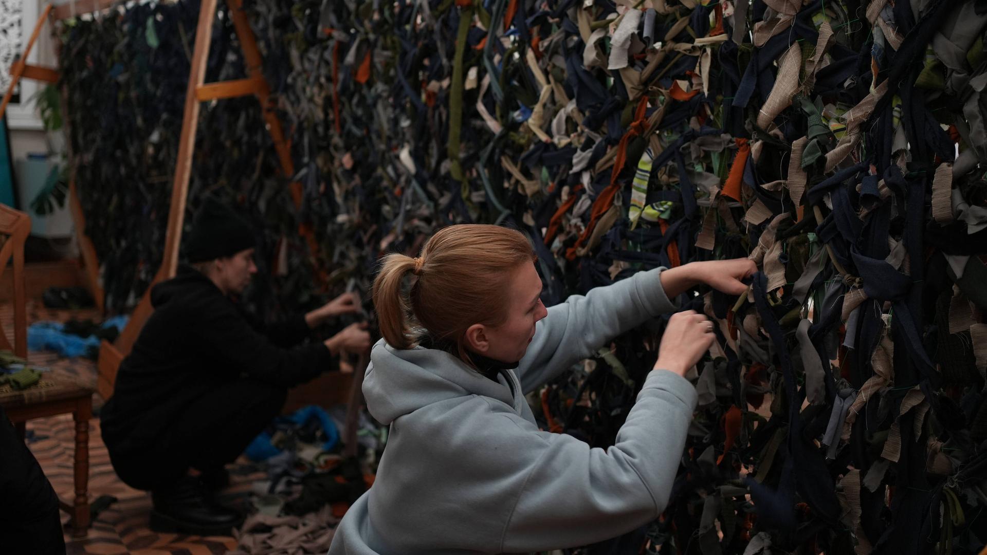 Menschen knüpfen Tarnnetze in Lviv, Ukraine am 28. Februar 2022. Menschen knüpfen Tarnnetze in Lviv, Ukraine am 28. Februar 2022.