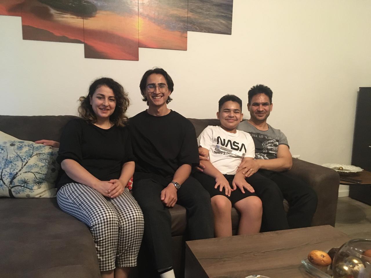 Familie Hekmat auf der Couch, die Mutter links, der Vater rechts, in der Mitte die beiden Söhne