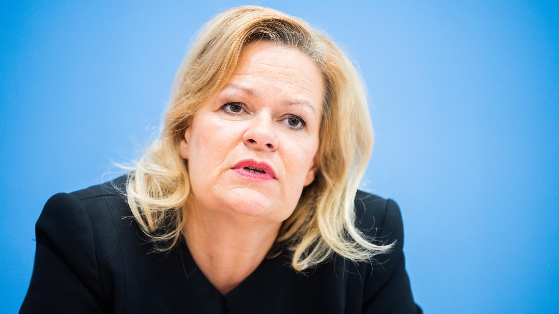 Bundesinnenminister Faeser spricht auf der Bundespressekonferenz. Sie trägt einen schwarzen Blazer und blickt ernst in die Kamera.