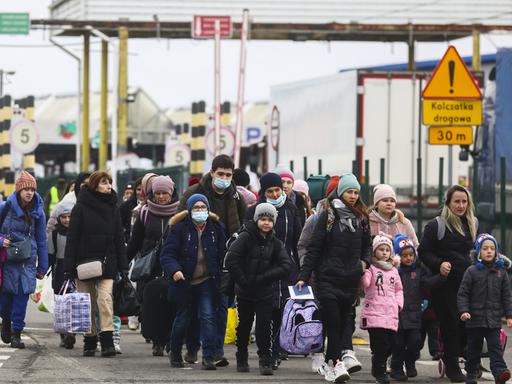 Flüchtlinge gehen auf einen Grenzübergang zu