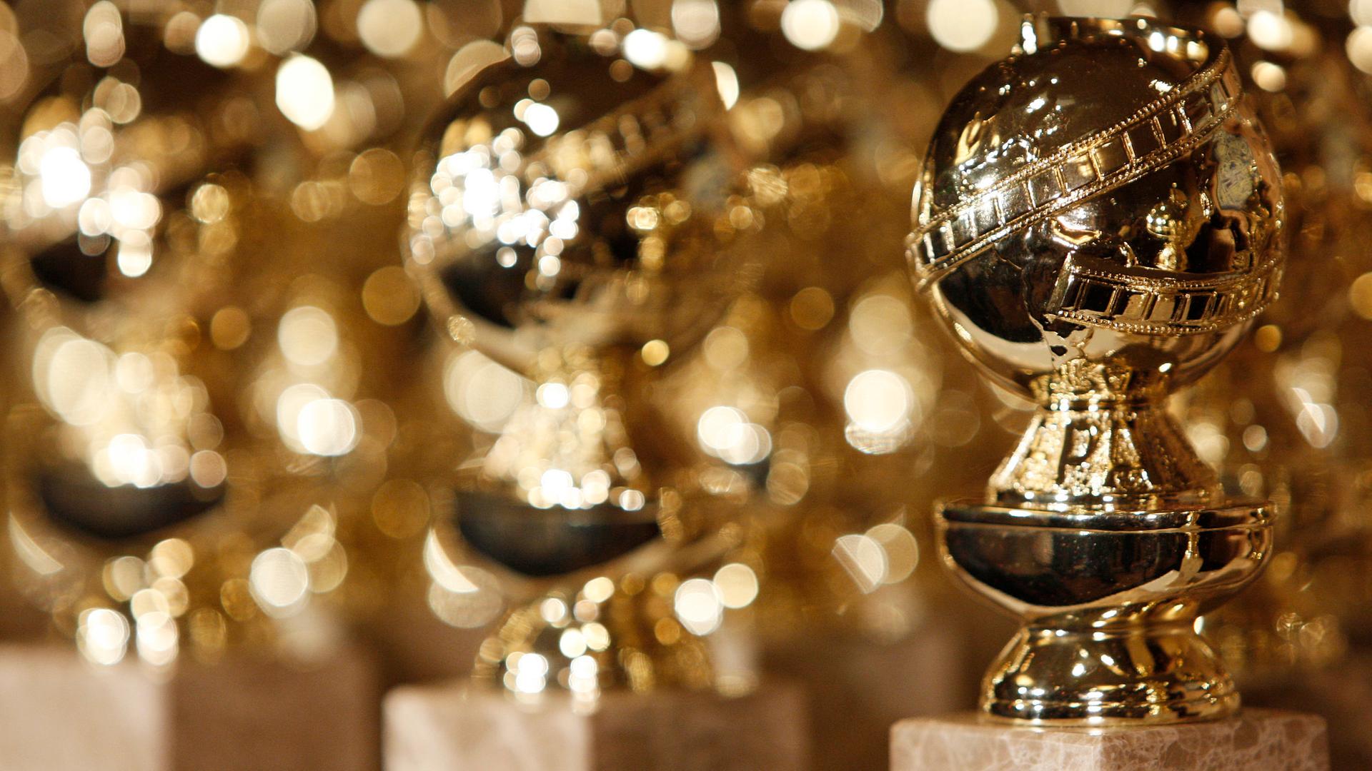 Das Bild zeigt mehrere Golden-Globe-Statuen, die nebeneinander stehen. Das Bild zeigt mehrere Golden-Globe-Statuen, die nebeneinander stehen.