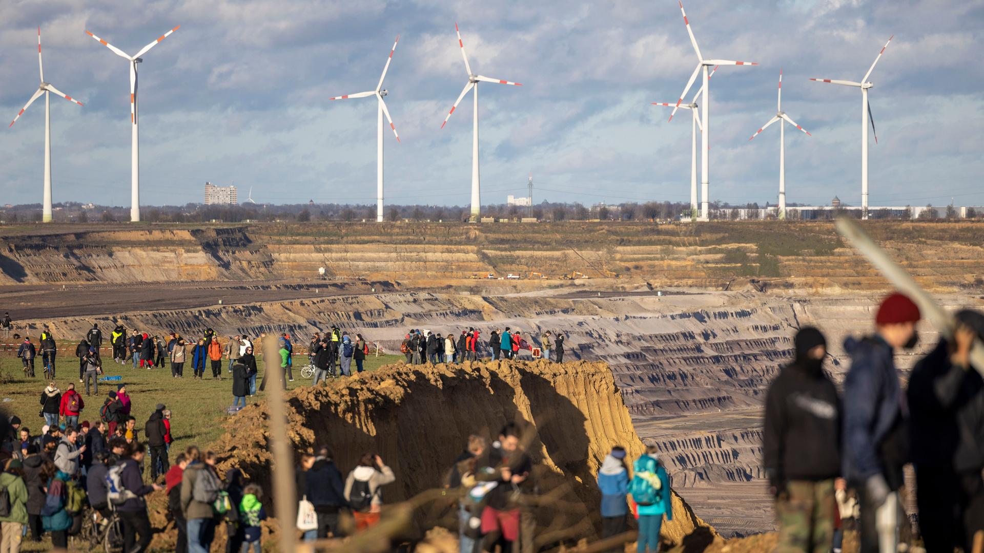 Besucher stehen direkt an der Kante des Tagebaus Garzweiler II in Lützerath, derweil bauen Aktivisten weitere Barrikaden. Lützerath soll zur Erweiterung des Braunkohletagebaus Garzweiler II abgebaggert werden. Besucher stehen direkt an der Kante des Tagebaus Garzweiler II in Lützerath, derweil bauen Aktivisten weitere Barrikaden. Lützerath soll zur Erweiterung des Braunkohletagebaus Garzweiler II abgebaggert werden.
