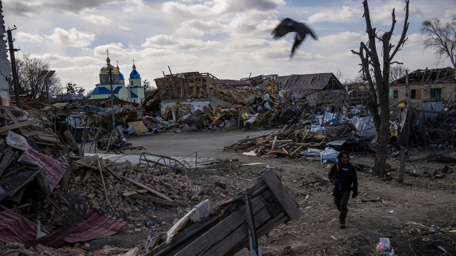Ein Journalist läuft durch einen zerstörten Vorort der ukrainischen Hauptstadt Kiew. Ein Journalist läuft durch einen zerstörten Vorort der ukrainischen Hauptstadt Kiew.