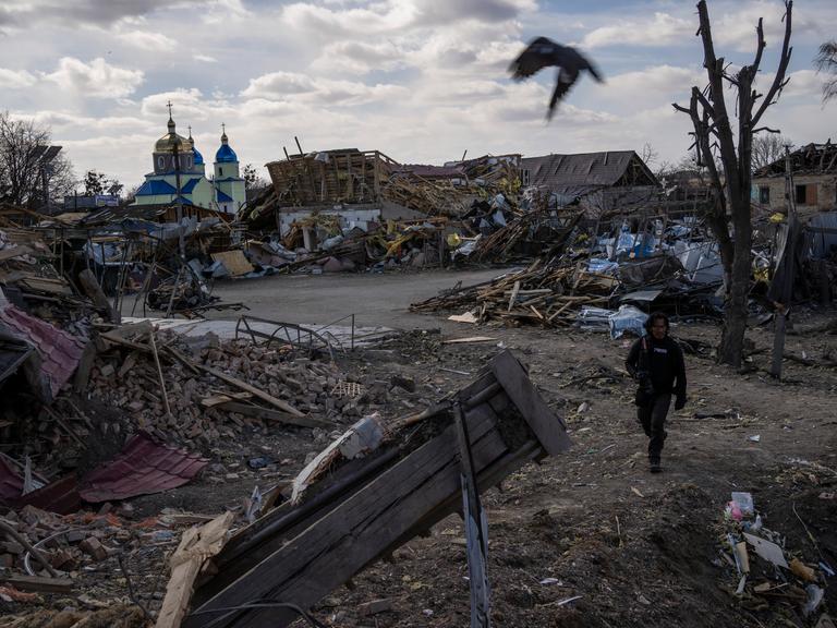 Ein Journalist läuft durch einen zerstörten Vorort der ukrainischen Hauptstadt Kiew.