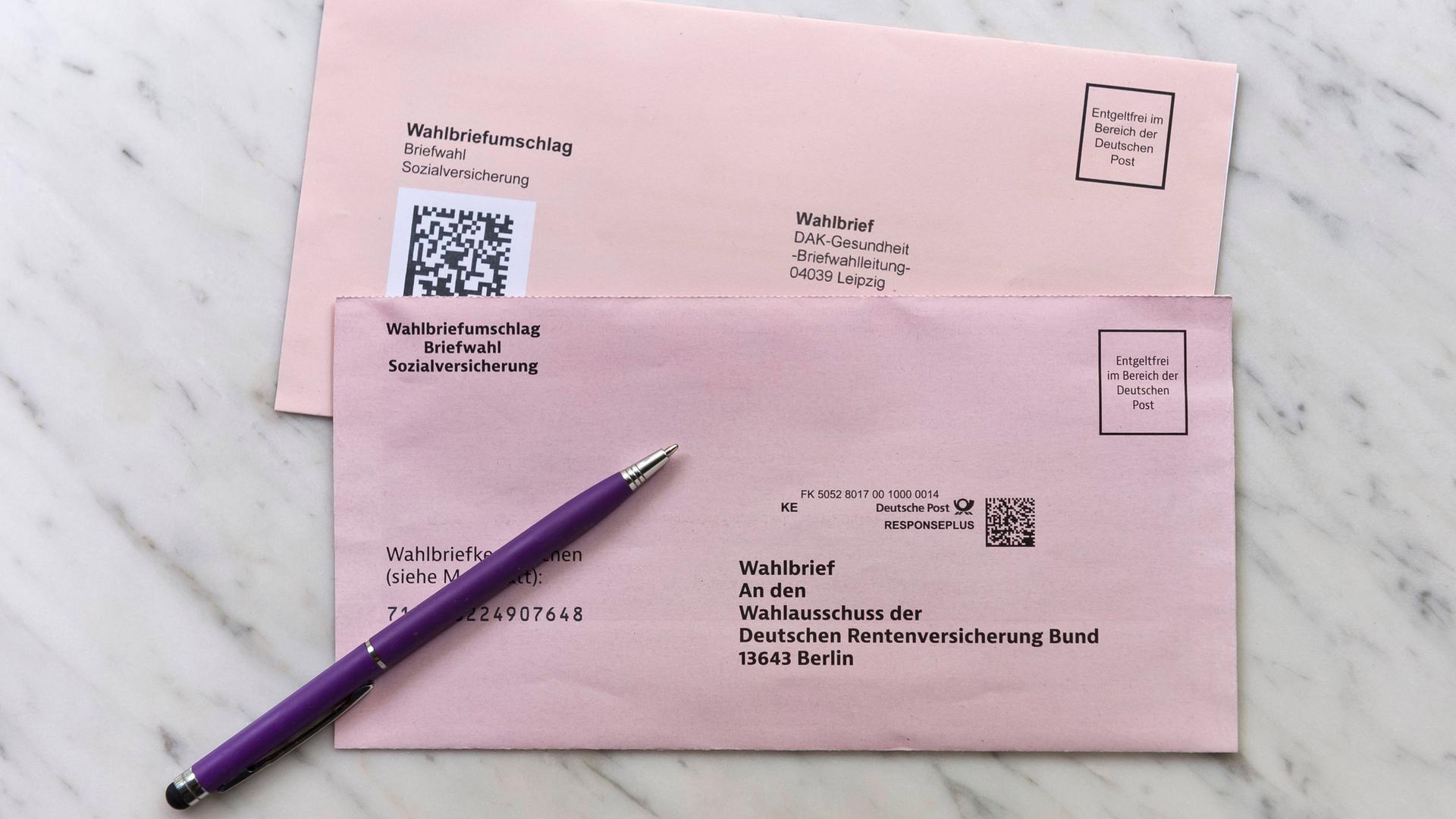 Zwei Briefe zur Sozialwahl 2023 liegen auf einem Marmortisch gemeinsam mit einem lila Kuli. Zwei Briefe zur Sozialwahl 2023 liegen auf einem Marmortisch gemeinsam mit einem lila Kuli.