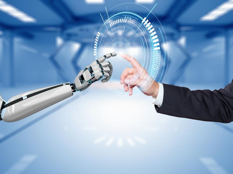 Eine Illustration zeigt, wie sich ein Roboter- und ein Menschenarm bzw. -finger aufeinander zubewegen und Kontakt suchen.