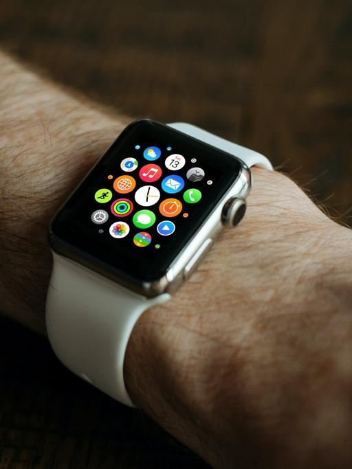 Eine Uhr mit digitalen Zusatzfunktionen, ein sogenanntes Wearable wird von einem Mann getragen.