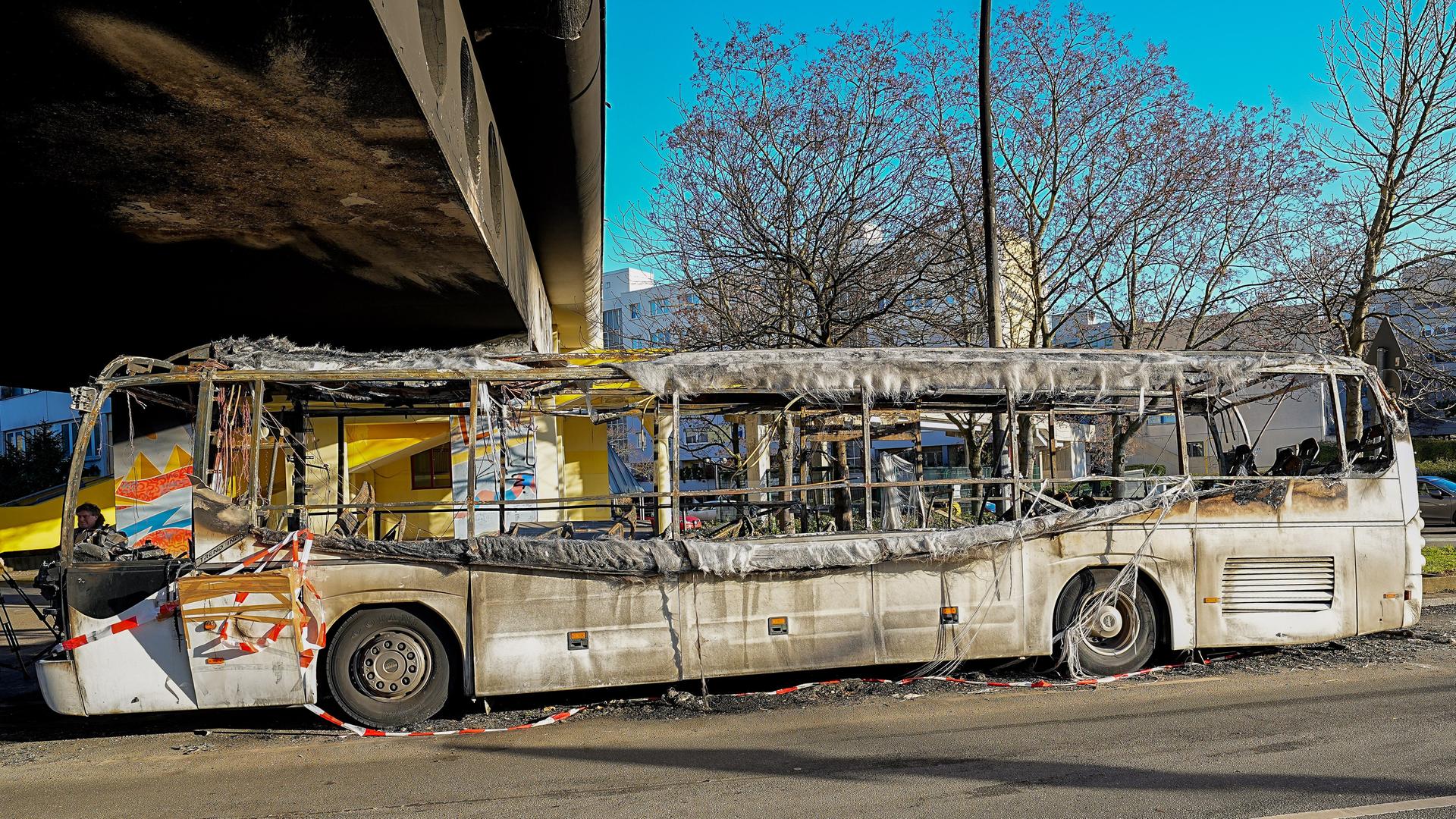 In der Berliner Sonnenallee im Berliner Stadtteil Neukölln steht unter einer Überbauung der Heideck-Siedlung das Wrack des Buses, der in der Silvesternacht 2022 komplett ausgebrannt ist. In der Berliner Sonnenallee im Berliner Stadtteil Neukölln steht unter einer Überbauung der Heideck-Siedlung das Wrack des Buses, der in der Silvesternacht 2022 komplett ausgebrannt ist.
