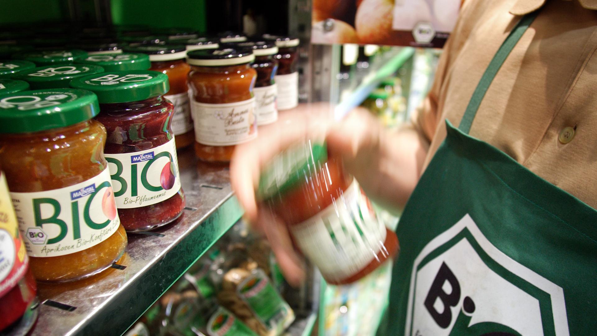 Auf einem Messestand der Grünen Woche 2007 stehen Biolebensmittel in einem Regal. Einer Person davor trägt eine grüne Schürze mit einem Aufdruck "Bio nach EG-Öko-Verordnung". Auf einem Messestand der Grünen Woche 2007 stehen Biolebensmittel in einem Regal. Einer Person davor trägt eine grüne Schürze mit einem Aufdruck "Bio nach EG-Öko-Verordnung".