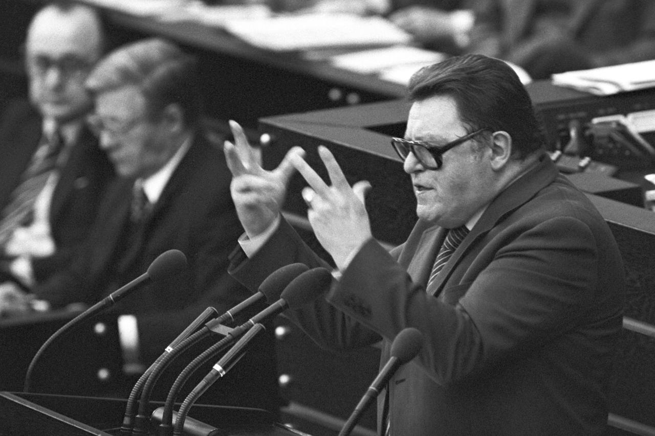 Der Parteivorsitzende der CSU Franz Josef Strauß spricht am 24.01.1978 im Bundestag in Bonn während der Haushaltsdebatte. Im Hintergrund sitzen (r-l) Bundeskanzler Helmut Schmidt und Außenminister Hans-Dietrich Genscher.