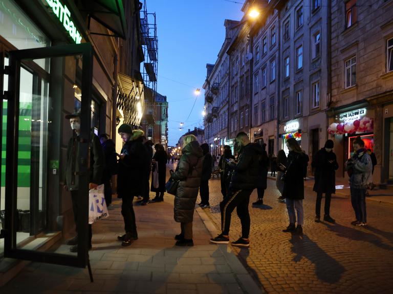 Menschen stehen Schlange vor einem Geldautomaten in Lviv (Lemberg)
