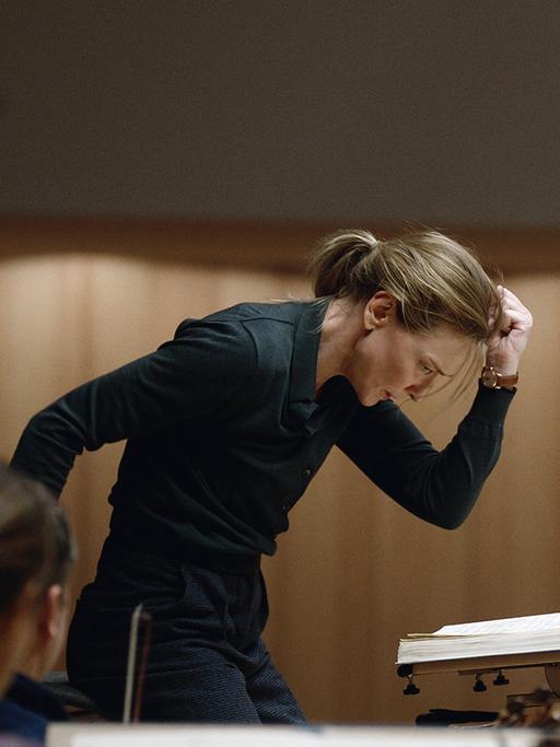 Cate Blanchett dirigiert in leidenschaftlicher Pose ein Orchester im Film "Tár", 2023.