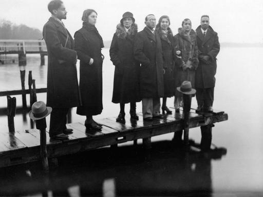 Sieben Personen stehen auf einem Bootssteg in Berlin in den 1920er Jahren.