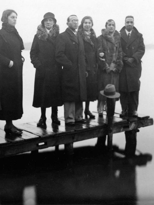 Sieben Personen stehen auf einem Bootssteg in Berlin in den 1920er Jahren.