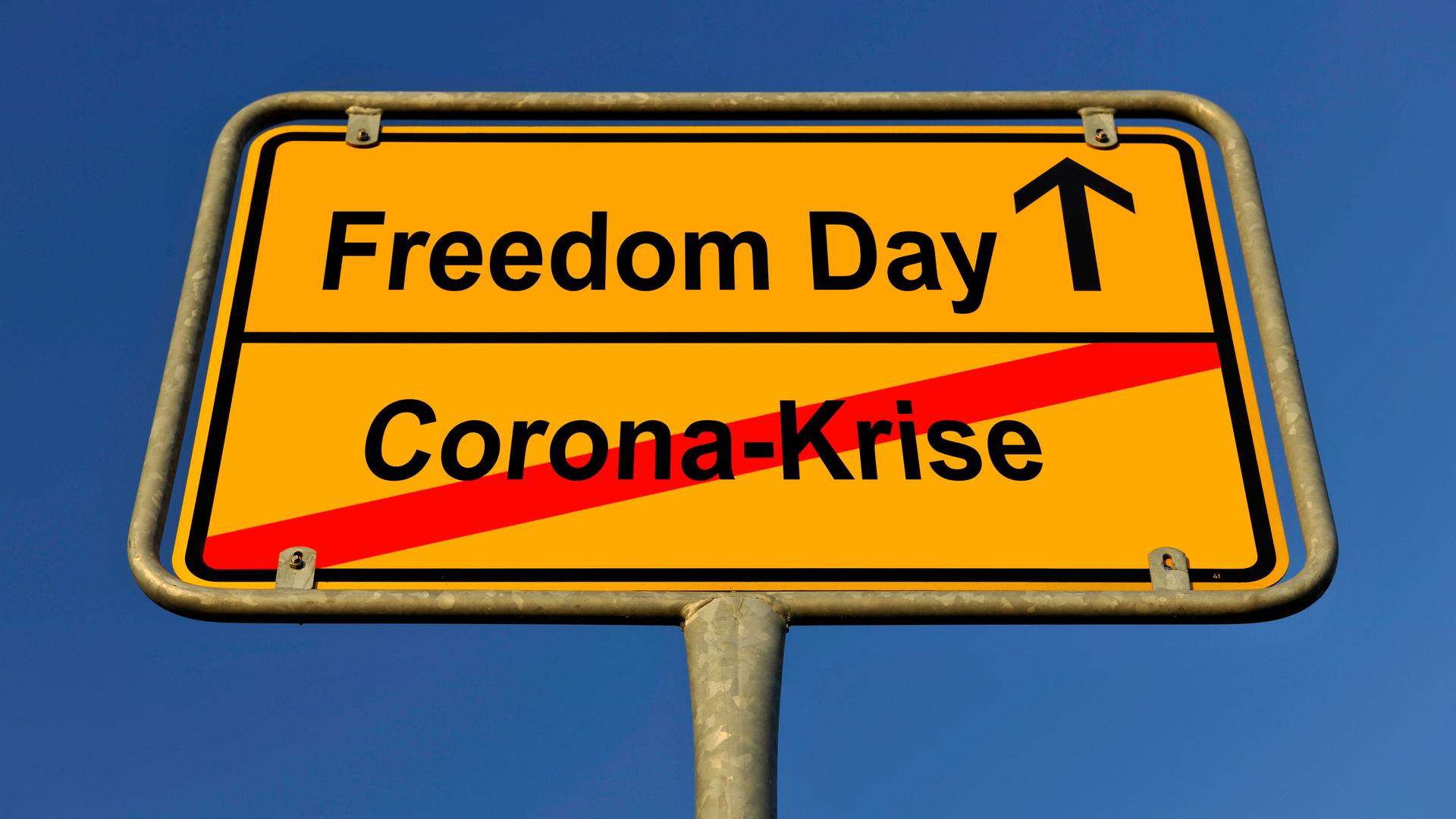 Ein Schild ist zu sehen, auf dem "Corona-Krise" durchgestrichen, darüber steht "Freedom Day". Ein Schild ist zu sehen, auf dem "Corona-Krise" durchgestrichen, darüber steht "Freedom Day".