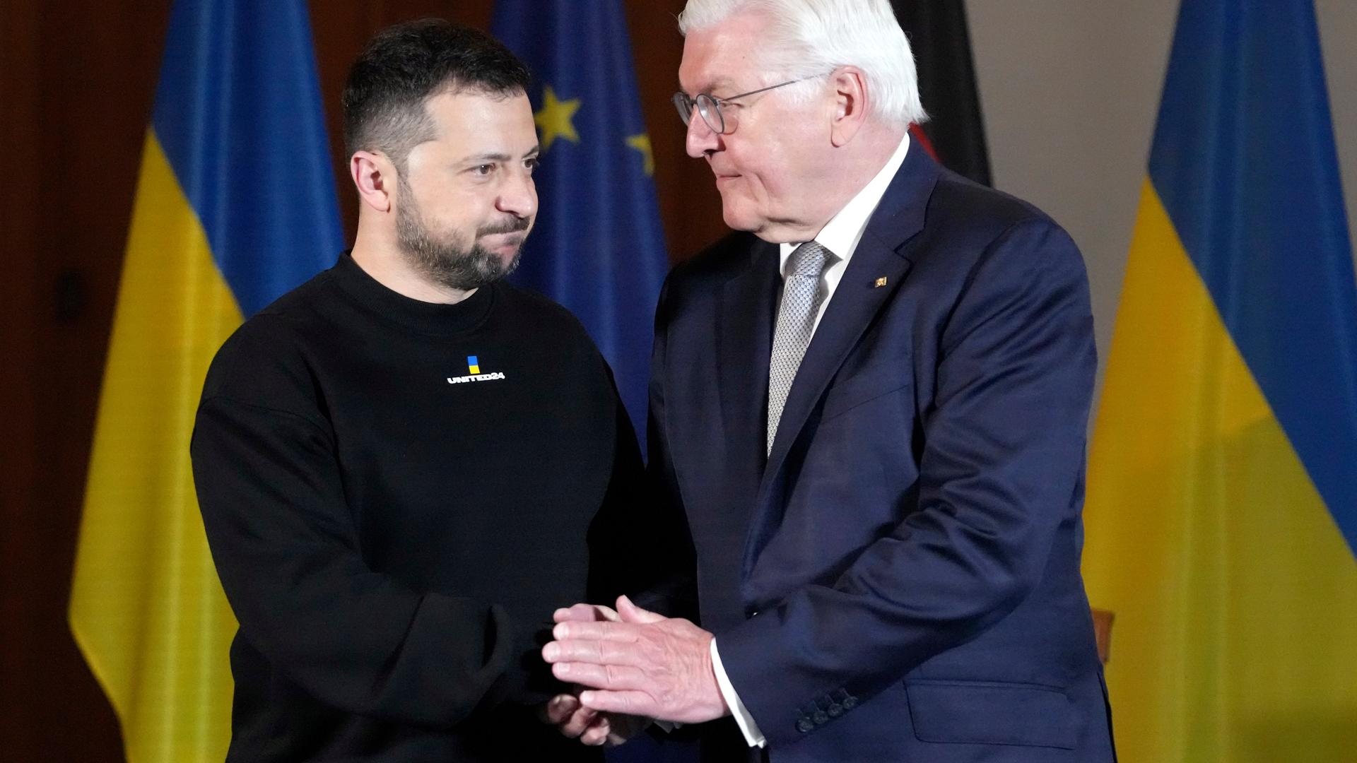 Das Foto zeigt den Präsidenten von der Ukraine und den deutschen Bundes-Präsidenten. Sie halten sich an den Händen fest. Das Foto zeigt den Präsidenten von der Ukraine und den deutschen Bundes-Präsidenten. Sie halten sich an den Händen fest.