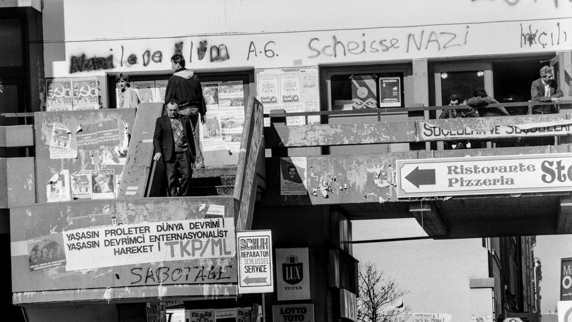 Foto des Gebäuderiegels "Zentrum Kreuzberg" in Berlin im Jahr 1990, auf der Fassade ist unter anderem der gesprayte Schriftzug "Scheisse Nazi" zu lesen.  