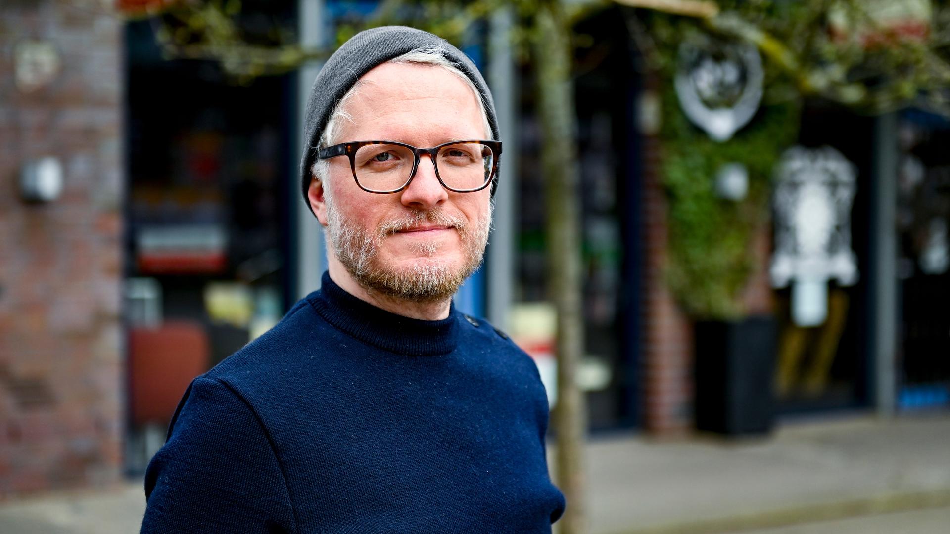 Verlagsleiter Daniel Beskos, Mitveranstalter des Indiebookday, einem Aktionstag zur Unterstützung kleiner unabhängiger Verlage, steht im Hamburger Schanzenviertel vor einer Buchhandlung. Er trägt eine Brille mit dunklem Gestell, Wollmütze und Fünf-Tage-Bart. Verlagsleiter Daniel Beskos, Mitveranstalter des Indiebookday, einem Aktionstag zur Unterstützung kleiner unabhängiger Verlage, steht im Hamburger Schanzenviertel vor einer Buchhandlung. Er trägt eine Brille mit dunklem Gestell, Wollmütze und Fünf-Tage-Bart.