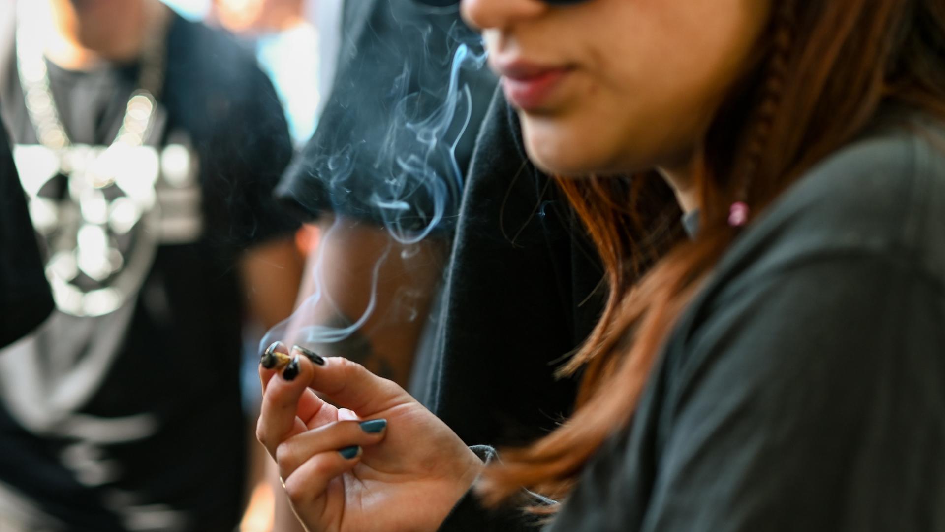 Eine junge Frau raucht einen Joint. Eine junge Frau raucht einen Joint.