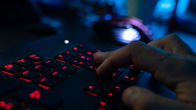 Ein Mann sitzt am Rechner und tippt auf einer Tastatur. Symbolfoto.