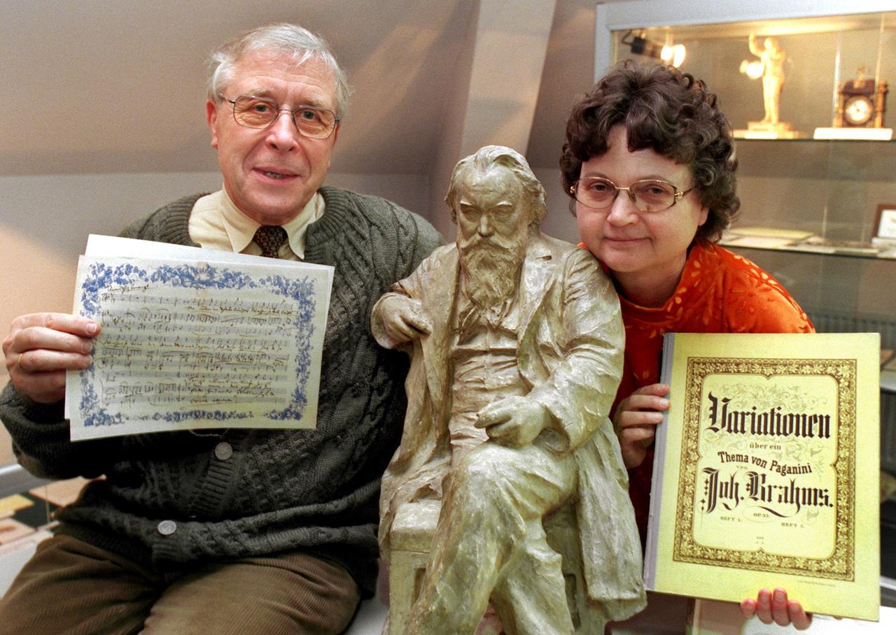 Die Sammler Kurt und Renate Hofmann haben eine Brahms-Figur zwischen sich und präsentieren auf dem Foto von 1998 Notenblätter und Bücher des Komponisten Johannes Brahms. Die Sammler Kurt und Renate Hofmann haben eine Brahms-Figur zwischen sich und präsentieren auf dem Foto von 1998 Notenblätter und Bücher des Komponisten Johannes Brahms.