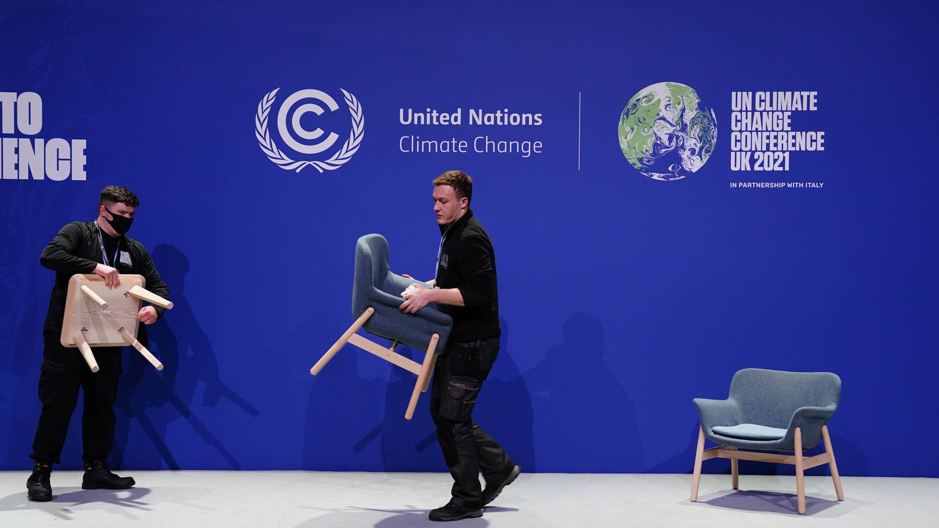 November 13, 2021, Glasgow, UK: Staff remove chairs and dismantle one of the stages, during an overun day of the Cop26 November 13, 2021, Glasgow, UK: Staff remove chairs and dismantle one of the stages, during an overun day of the Cop26