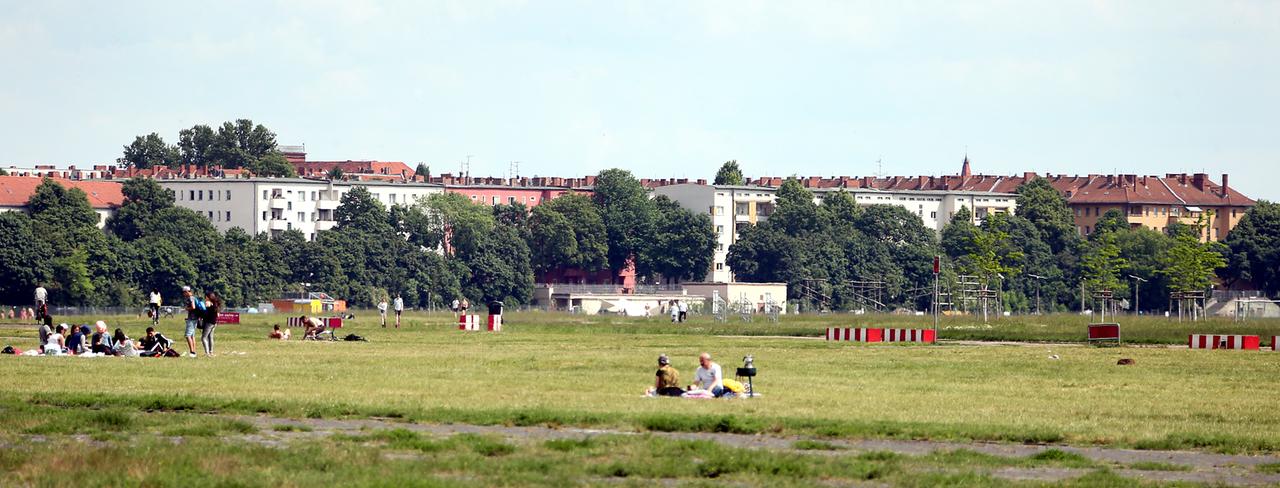 Menschen sitzen und stehen auf dem ehemaligen Flughafen Berlin-Tempelhof, nahe der Oderstraße im Schillerkiez in Neukölln, auf einer Wiese. Menschen sitzen und stehen auf dem ehemaligen Flughafen Berlin-Tempelhof, nahe der Oderstraße im Schillerkiez in Neukölln, auf einer Wiese.