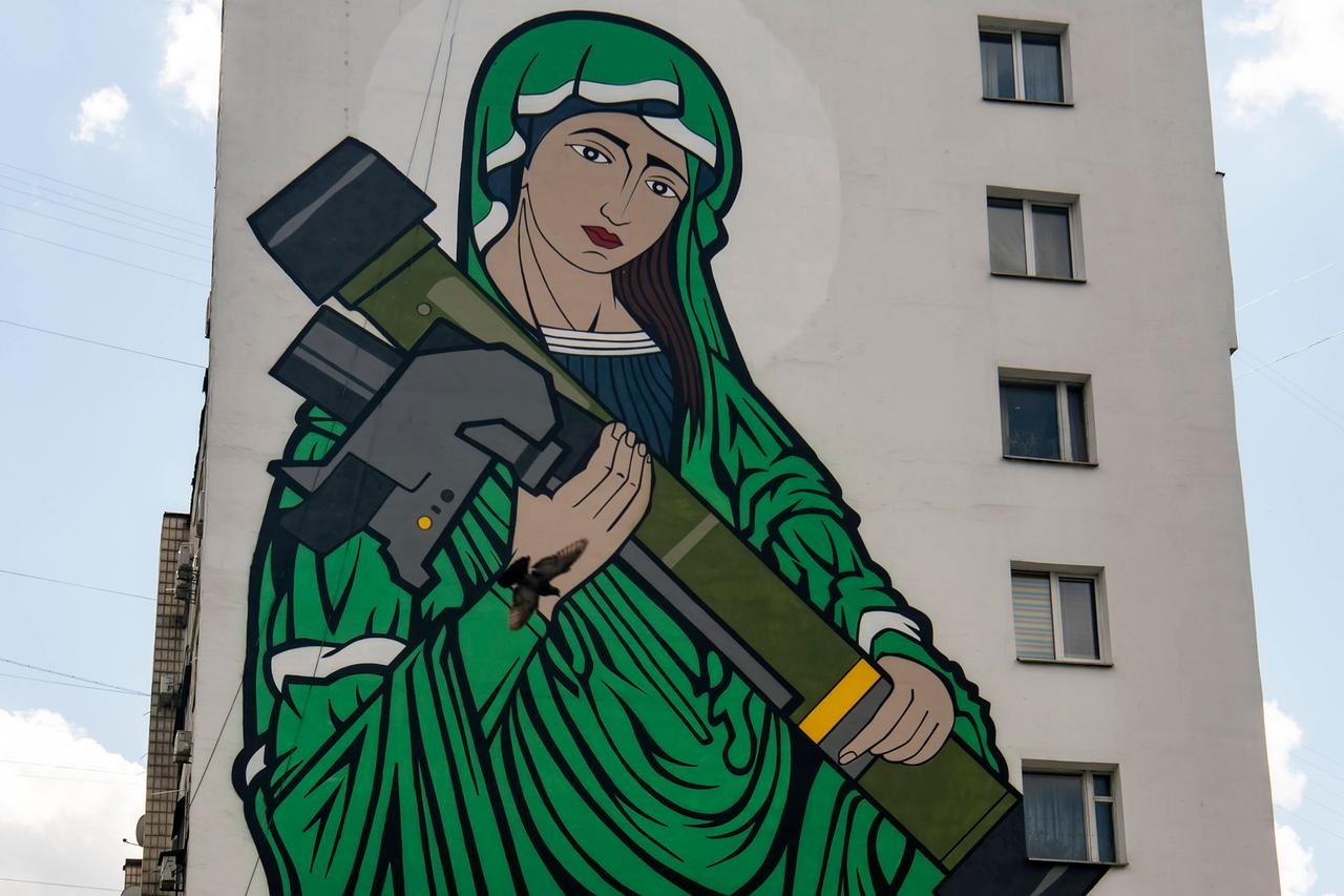Dieses ikonische Bild hat sich durch den Ukrainekrieg weit verbreitet: die "Heilige" Javelina, eine Madonna in Tarngrün, in den Armen eine Javelin-Panzerfaust aus US-Fertigung. Hier zu sehen auf einer Hauswand in Kiew. Dieses ikonische Bild hat sich durch den Ukrainekrieg weit verbreitet: die "Heilige" Javelina, eine Madonna in Tarngrün, in den Armen eine Javelin-Panzerfaust aus US-Fertigung. Hier zu sehen auf einer Hauswand in Kiew.