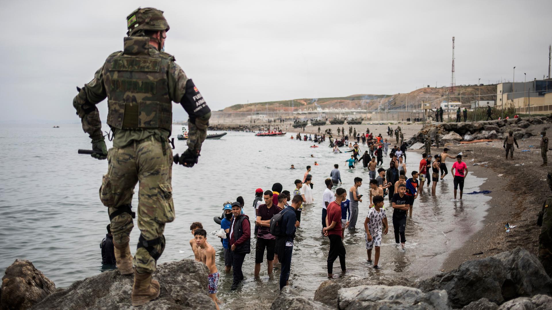 Menschen, hauptsächlich aus Marokko, stehen am Ufer, als die spanische Armee das Gebiet an der Grenze zwischen Marokko und Spanien in der spanischen Enklave Ceuta am Dienstag, 18. Mai 2021, absperrt. Ceuta, eine spanische Stadt mit 85 000 Einwohnern in Nordafrika, steht vor einer humanitären Krise, nachdem Tausende Marokkaner die gelockerten Grenzkontrollen in ihrem Land genutzt haben, um schwimmend oder in Schlauchbooten nach Europa zu gelangen. Menschen, hauptsächlich aus Marokko, stehen am Ufer, als die spanische Armee das Gebiet an der Grenze zwischen Marokko und Spanien in der spanischen Enklave Ceuta am Dienstag, 18. Mai 2021, absperrt. Ceuta, eine spanische Stadt mit 85 000 Einwohnern in Nordafrika, steht vor einer humanitären Krise, nachdem Tausende Marokkaner die gelockerten Grenzkontrollen in ihrem Land genutzt haben, um schwimmend oder in Schlauchbooten nach Europa zu gelangen.