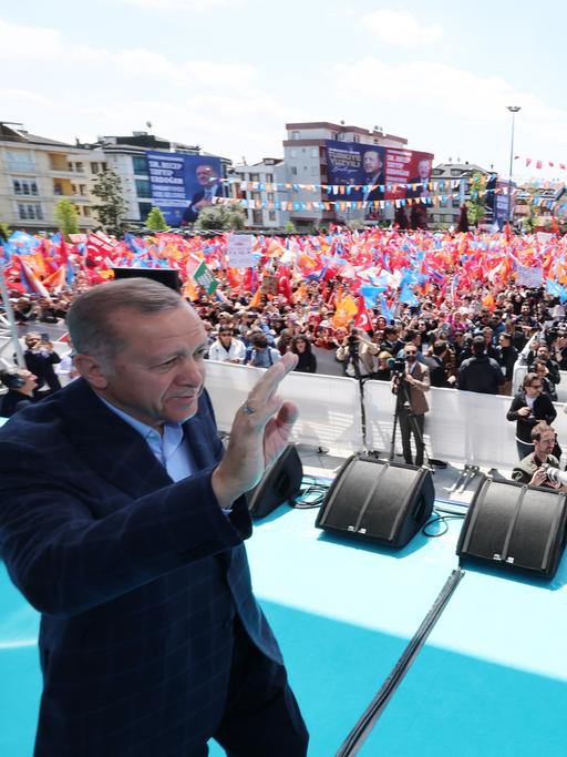 Der türkische Präsident Recep Tayyip Erdogan läuft bei einer Wahlkampfveranstaltung vor Beginn der Präsidentschaftswahlen in der Türkei über eine Bühne und winkt. 