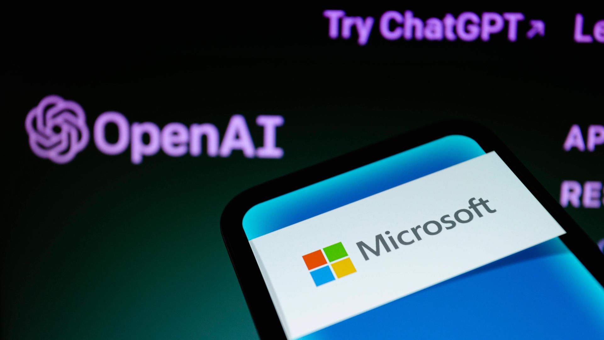 Ein Smartphone mit Microsoft-Logo vor einen ChatGPT-Hintergrund.