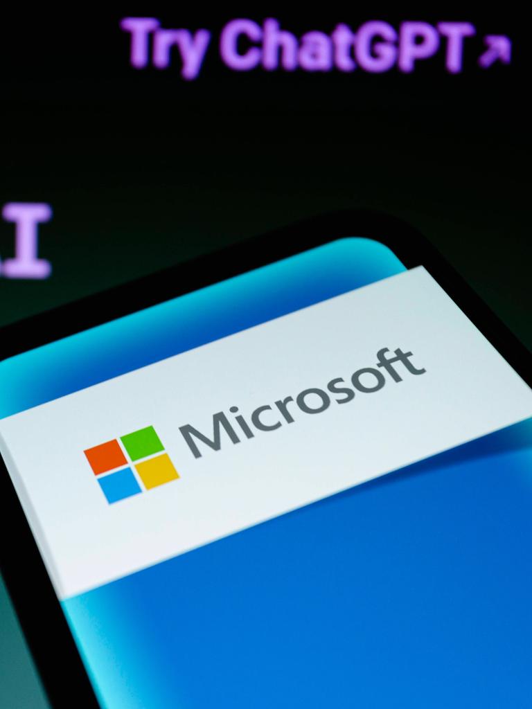 Ein Smartphone mit Microsoft-Logo vor einen ChatGPT-Hintergrund.