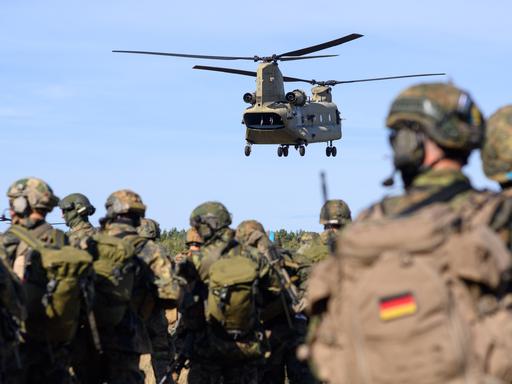 Soldaten des Falschirmjägerregiments 26 warten auf die Landung eines Chinook C-47 Hubschraubers der US-Army, der die Soldaten für eine Übung aufnehmen soll.
