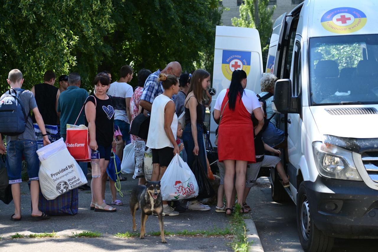 Einwohner der Stadt Slowjansk stehen mit Taschen und Koffern vor einem Bus, um aus der Stadt zu fliehen. Einwohner der Stadt Slowjansk stehen mit Taschen und Koffern vor einem Bus, um aus der Stadt zu fliehen.