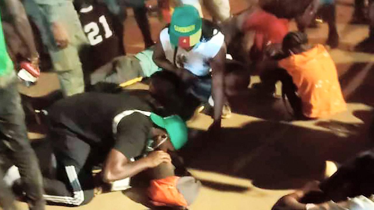 Menschen helfen den Opfern von einer Massen-Panik vor einem Stadion in der Stadt Janúnde in Kamerun. Menschen helfen den Opfern von einer Massen-Panik vor einem Stadion in der Stadt Janúnde in Kamerun.