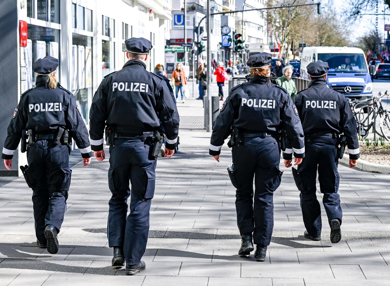 Polizisten patrouillieren vor dem Eingang zu einem Supermarkt auf einer Einkaufsstraße in Hamburg. Polizisten patrouillieren vor dem Eingang zu einem Supermarkt auf einer Einkaufsstraße in Hamburg.