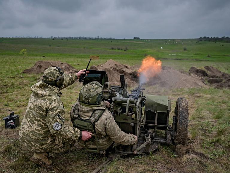 Ukrainische Soldaten feuern auf einem Feld eine Rakete ab