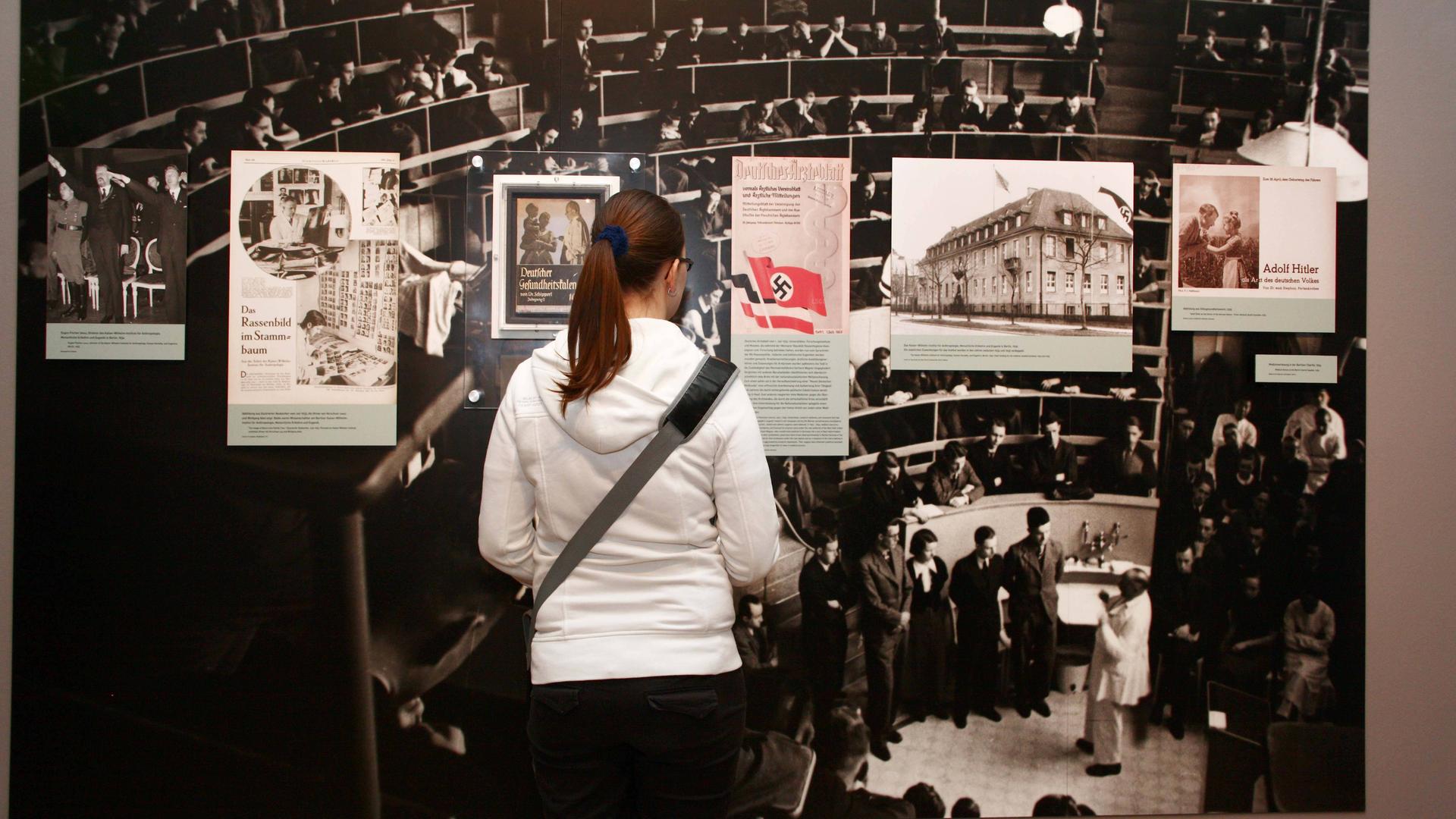 Ausstellung - Tödliche Medizin: Rassenwahn im Nationalsozialismus - im Jüdischen Museum in Berlin / Besucherin vor einem Bild, welches eine Vorlesung an der Berliner Charite zeigt Ausstellung - Tödliche Medizin: Rassenwahn im Nationalsozialismus - im Jüdischen Museum in Berlin / Besucherin vor einem Bild, welches eine Vorlesung an der Berliner Charite zeigt
