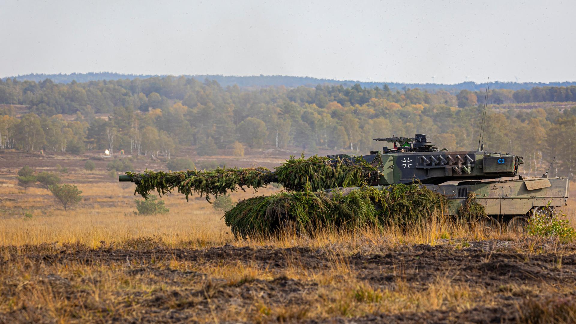 Ein Kampfpanzer der Bundeswehr vom Typ Leopard 2 fährt über einen Truppenübungsplatz. Ein Kampfpanzer der Bundeswehr vom Typ Leopard 2 fährt über einen Truppenübungsplatz.