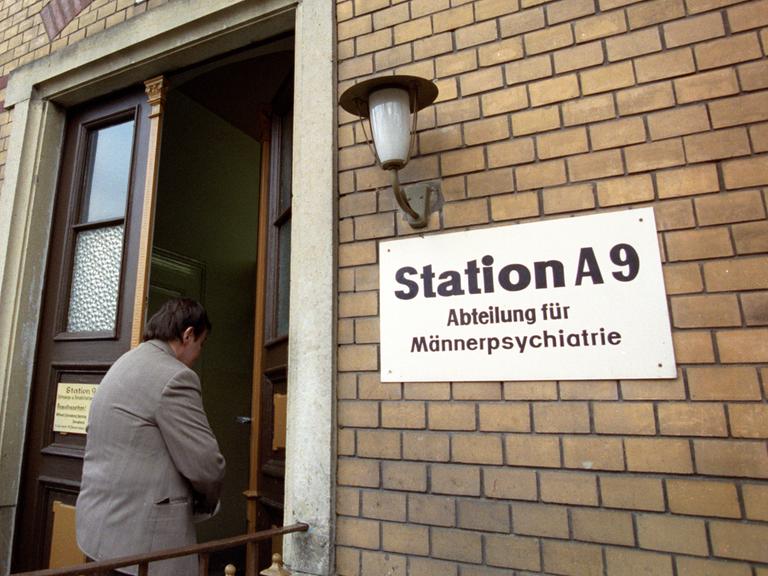 Neben der Eingangstür eines Backsteingebäudes hängt ein Schild mit der Aufrschrift "Station A9 - Abteilung für Männerpsychiatrie".