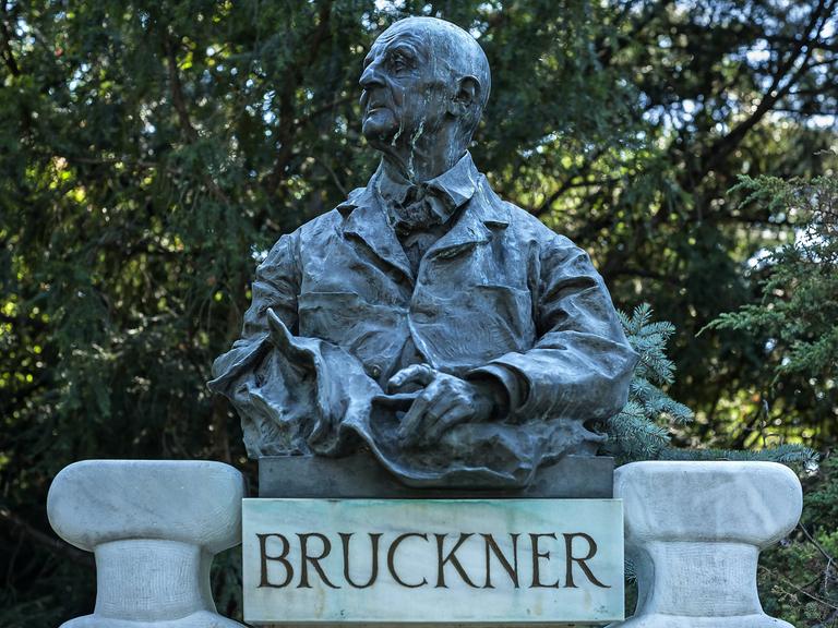 Büste des Komponisten Anton Bruckner (1824-1896) im Stadtpark Wien in Österreich. Am Kopf der Büste laufen streifenförmige Verschmutzungen von oben nach unten. 