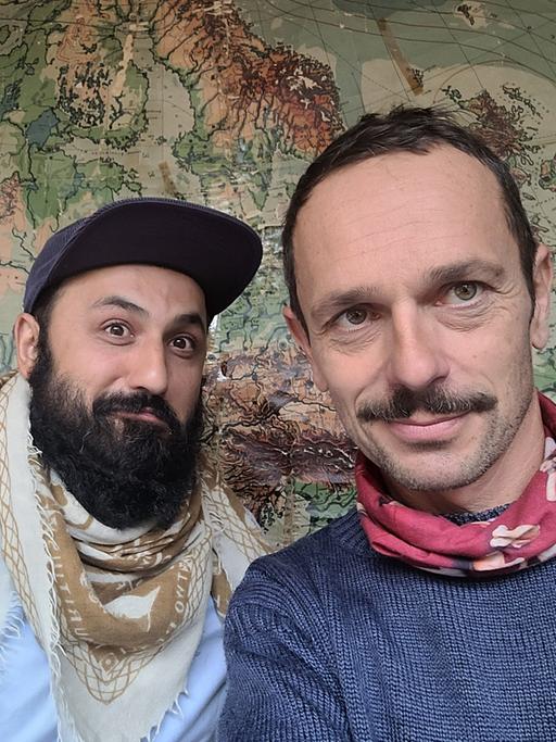 Selfie von Florian Schönhofer und dem Arzt Atal Rasoul vor einer Landkarte.