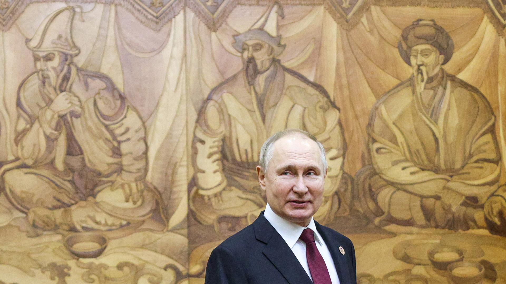 Russlands Präsident Wladimir Putin am Rande eines Treffens in Kirgistan im Dezember 2002. Im Hintergrund ein traditionelles Wandgemälde Russlands Präsident Wladimir Putin am Rande eines Treffens in Kirgistan im Dezember 2002. Im Hintergrund ein traditionelles Wandgemälde