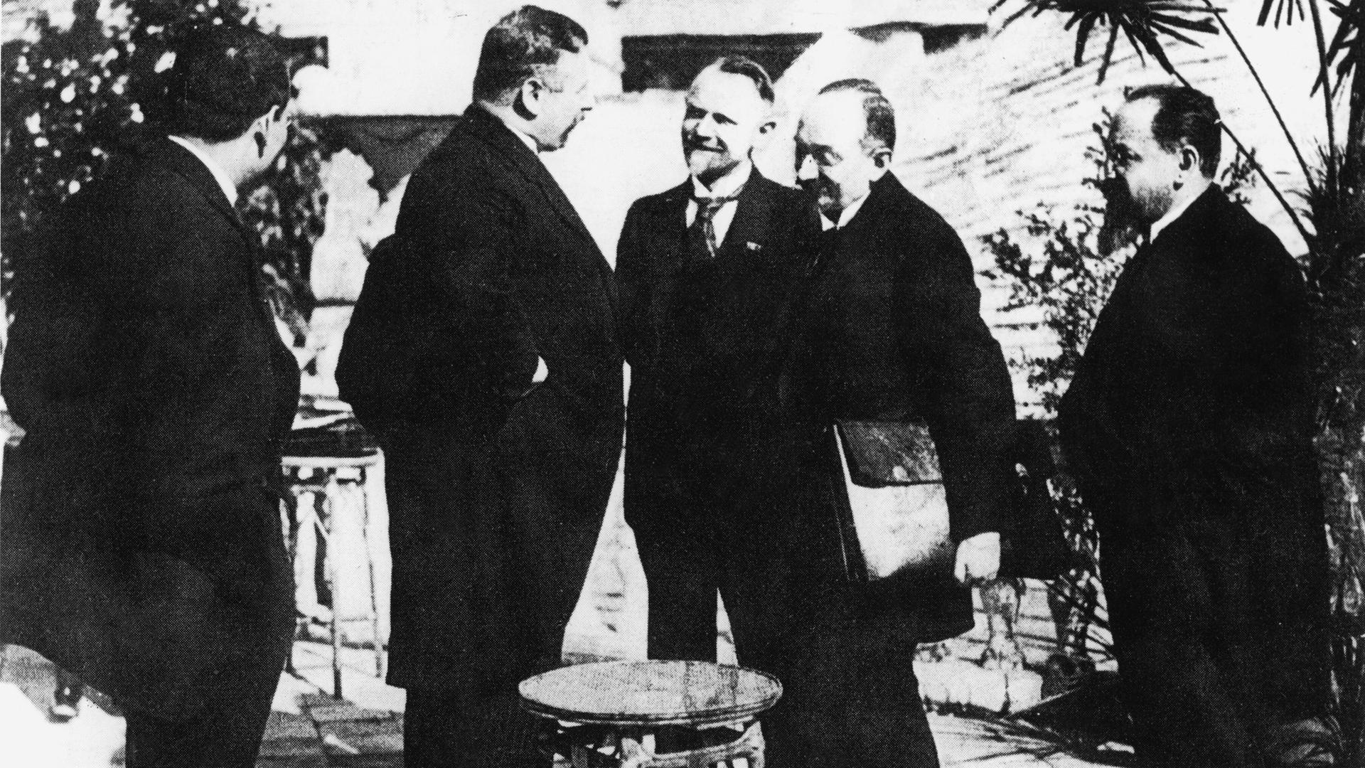 Reichskanzler Joseph Wirth (Mitte, im Profil), der sowjetische Volkskommissar für Aussenhandel Krassin (3.v.r) und der Volkskommissar des Äusseren Tschitsche- rin (2.v.r.), während der Konferenz in Rapallo.- Foto, 16. April 1922. Reichskanzler Joseph Wirth (Mitte, im Profil), der sowjetische Volkskommissar für Aussenhandel Krassin (3.v.r) und der Volkskommissar des Äusseren Tschitsche- rin (2.v.r.), während der Konferenz in Rapallo.- Foto, 16. April 1922.