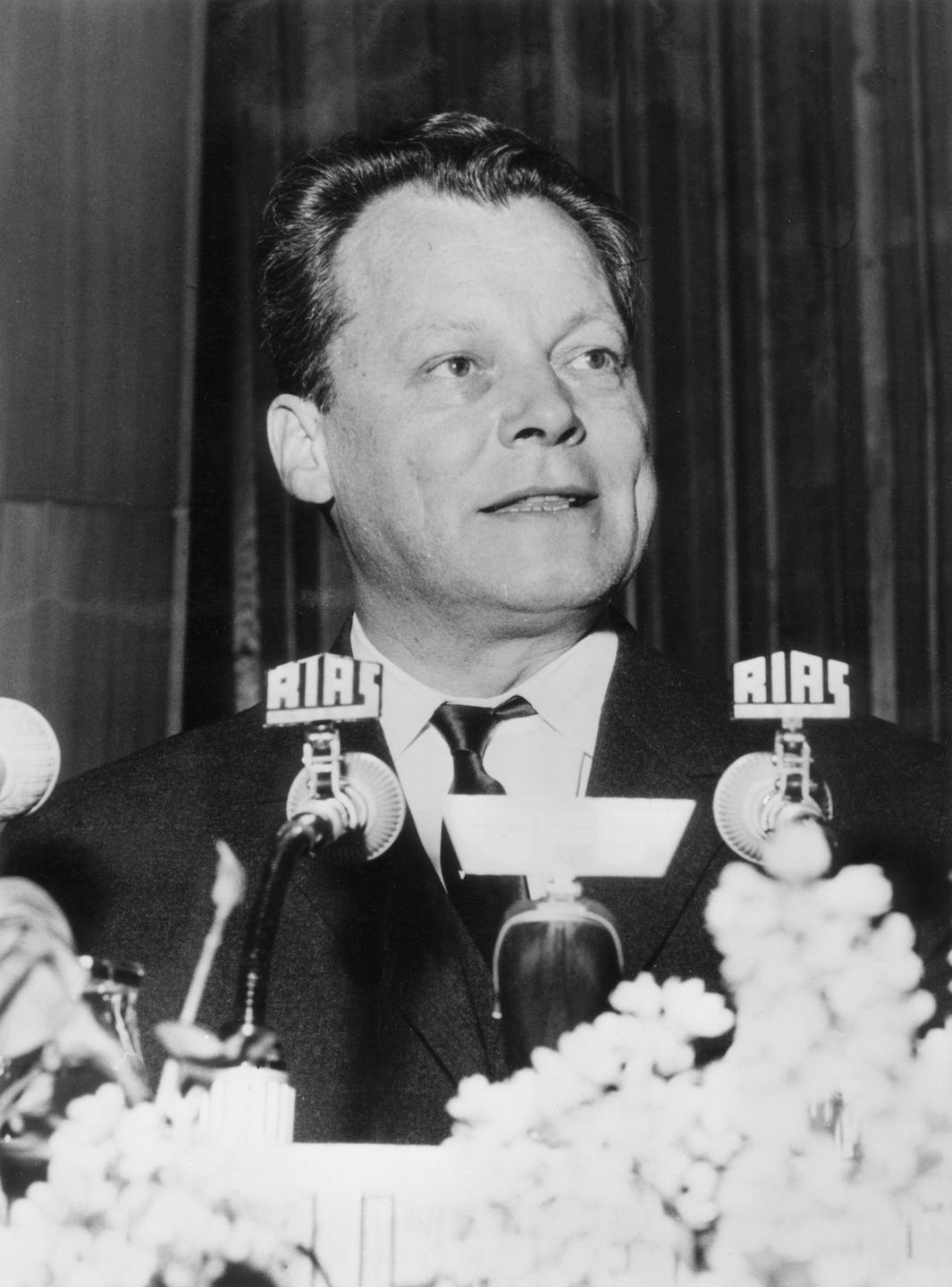 Willy Brandt 1961. Ein Mann steht vor einem Mikrofon. Willy Brandt 1961. Ein Mann steht vor einem Mikrofon.
